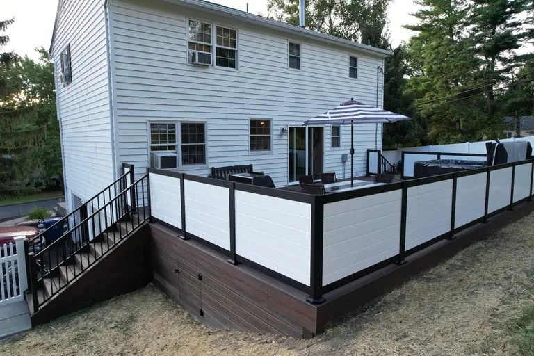 Composite deck with white-panel, black-frame privacy railing and string lights, Dutchess County, NY