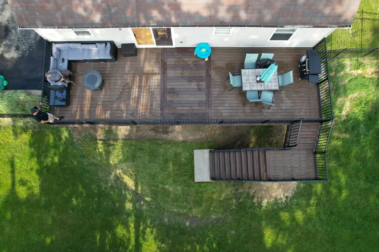 Aerial view of a long composite deck with sectional sofa, dining set, and grill station, Dutchess County, NY