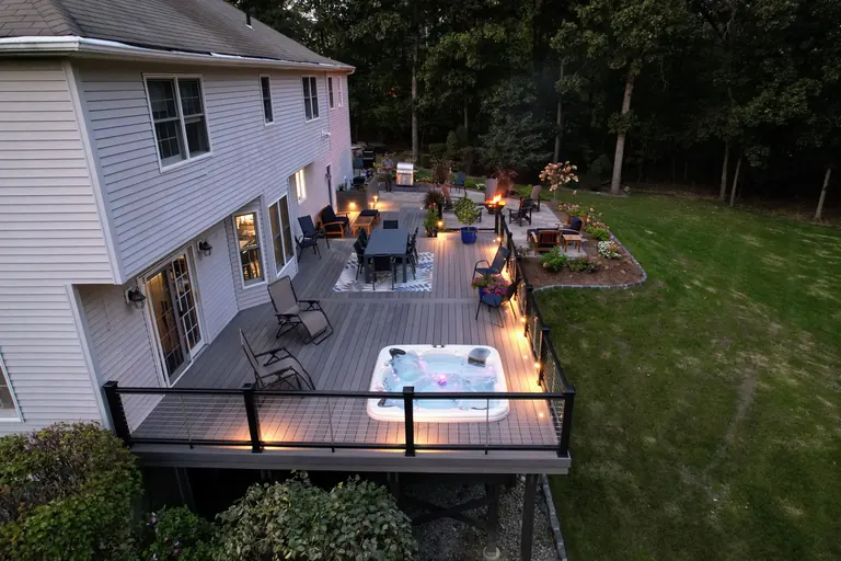 Finished back deck with hot tub and cable railing at dusk, LaGrange, NY