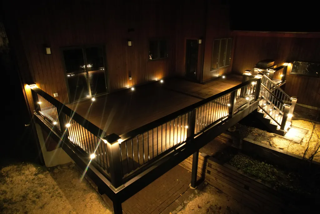 Deck at night with post and rail lights glowing along the railing and stairs