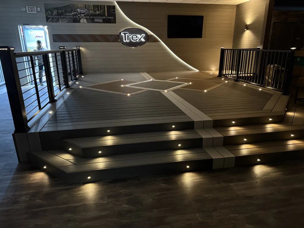 Indoor Trex showroom deck with lit steps, an inlaid board pattern and black cable railing