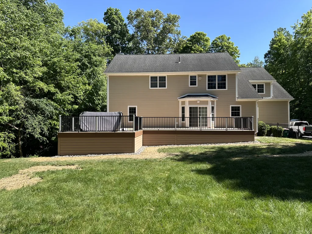 Tan-sided colonial rear deck with black cable rail and a covered hot tub, Dutchess County, NY