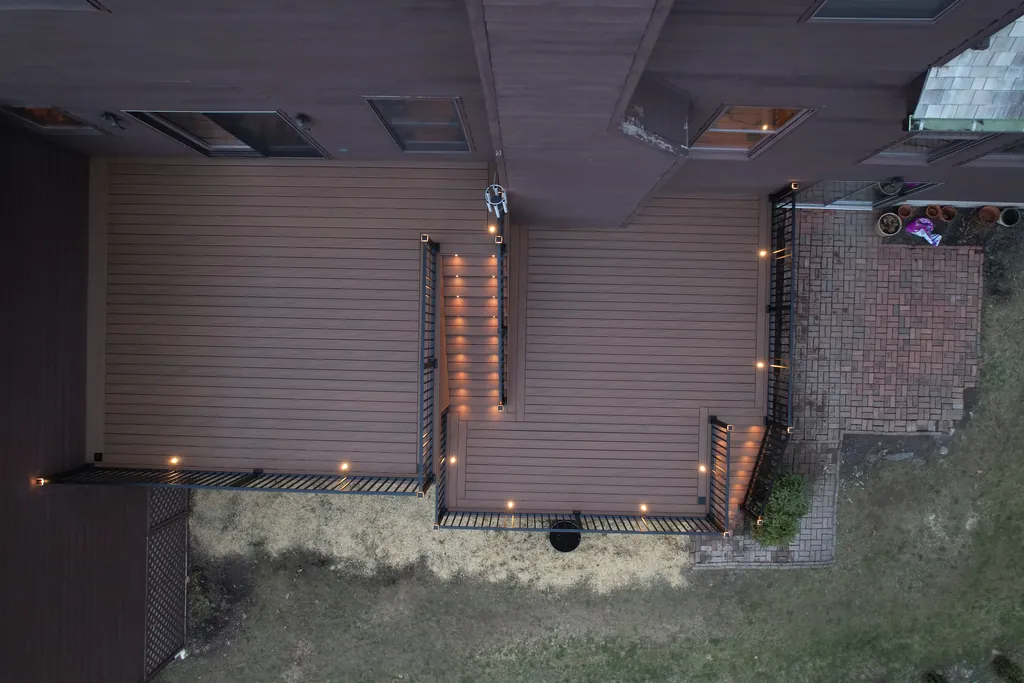 Night view of the same two-level composite deck with lit stair risers, Dutchess County, NY