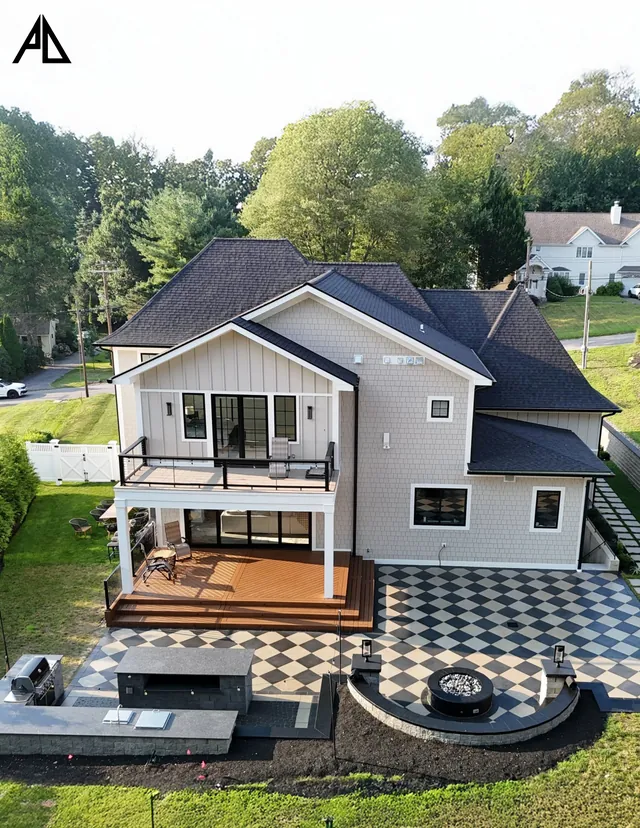 Two-story deck above a checkerboard patio and outdoor kitchen