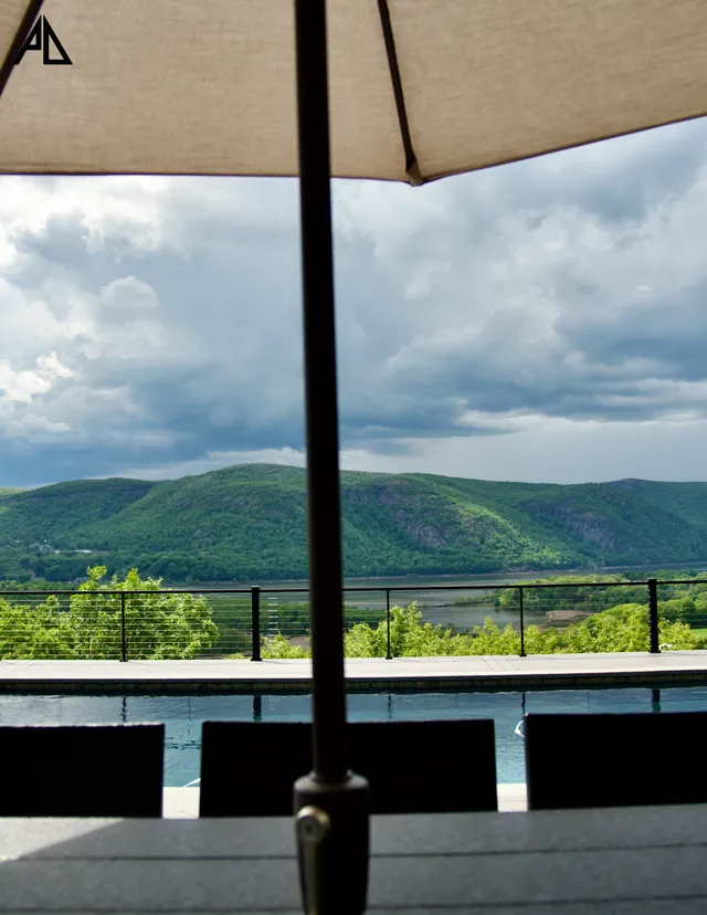 Dining deck under an umbrella with mountains beyond