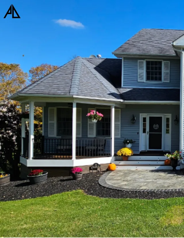 Wraparound front porch with white railing and flowers
